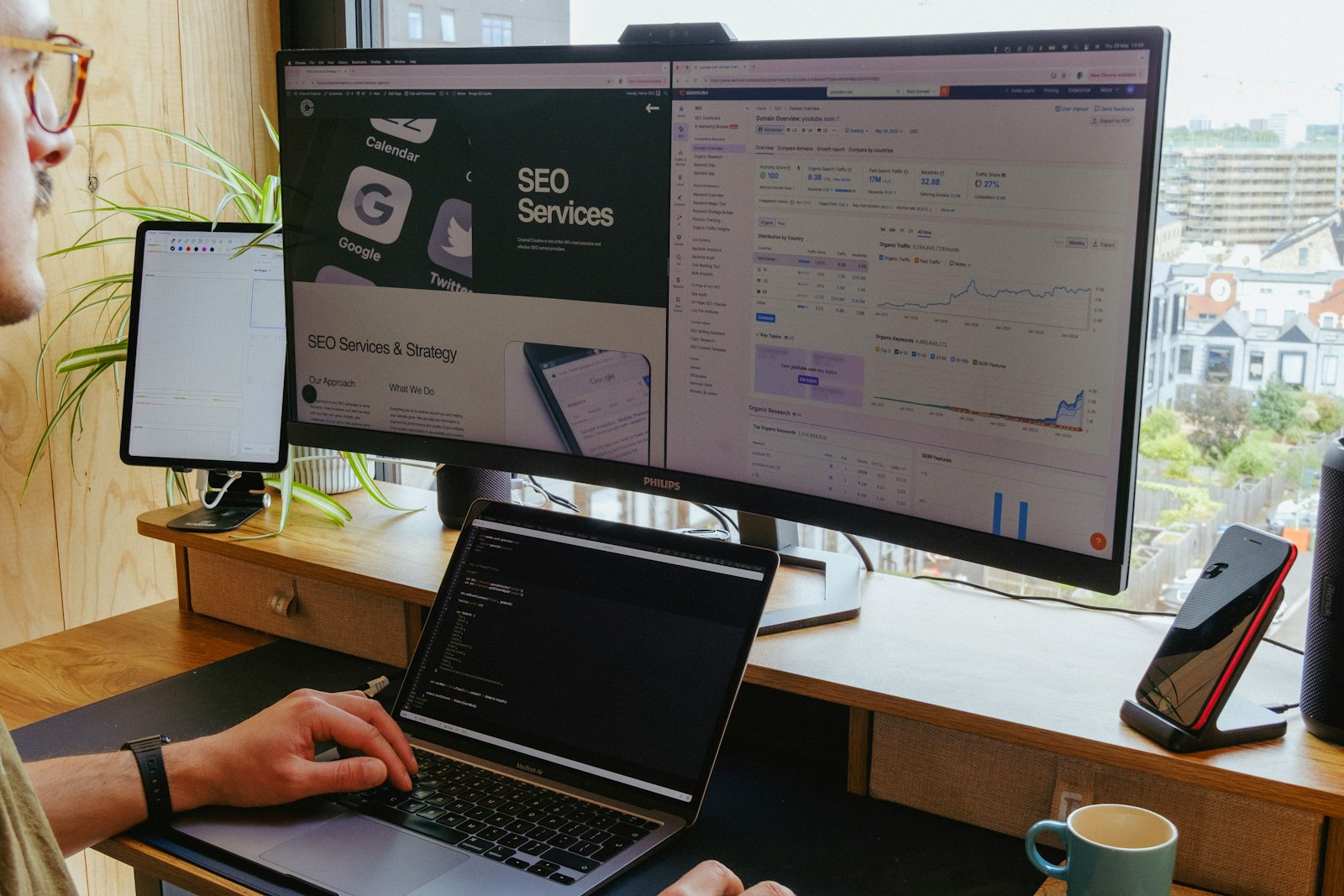 Estación de trabajo multi-monitor mostrando un sitio web y un dashboard de SEO